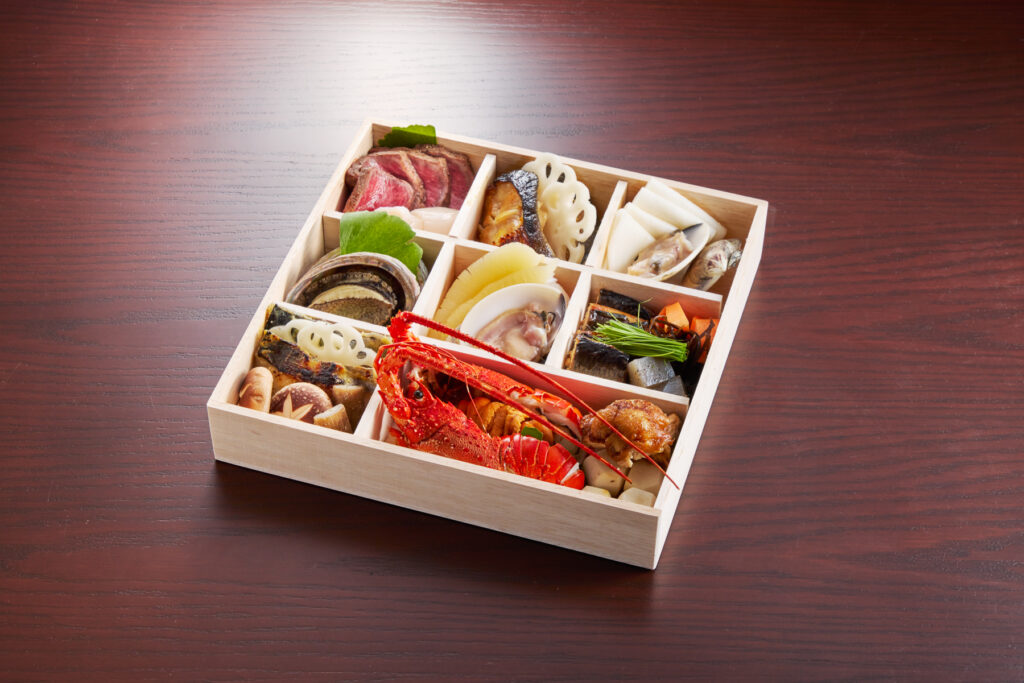 鮨悠 謹製おせち三段重の一段。伊勢海老・雲丹・鮑・牛肉・蛤などを詰めたお重